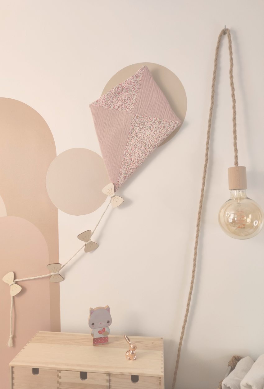 Décoration murale pour enfants en forme de cerf-volant accrochée sur le mur d'une chambre  avec une suspension lumineuse.