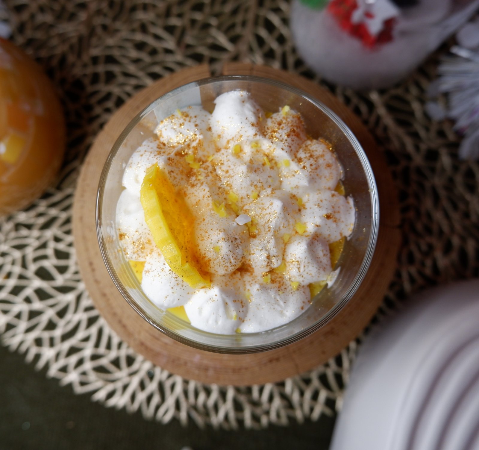 Bougie parfum citron meringué avec une base jaune, une couche de chantilly blanche et une tranche de citron sur le dessus