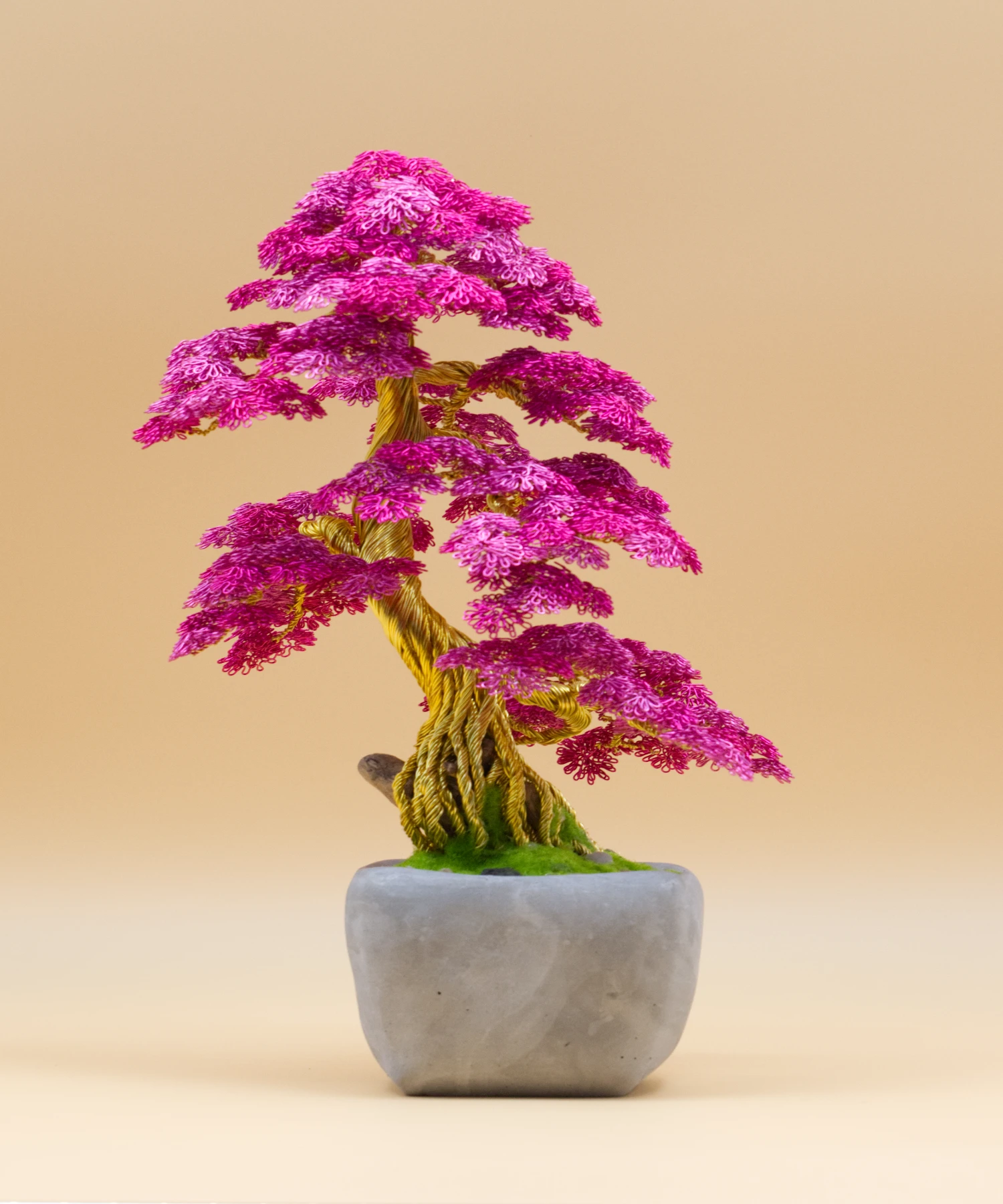 Bonsaï en fil de fer « Murmure Fuchsia », feuillage rose fuchsia, tronc doré aux fils entrelacés, pot gris.