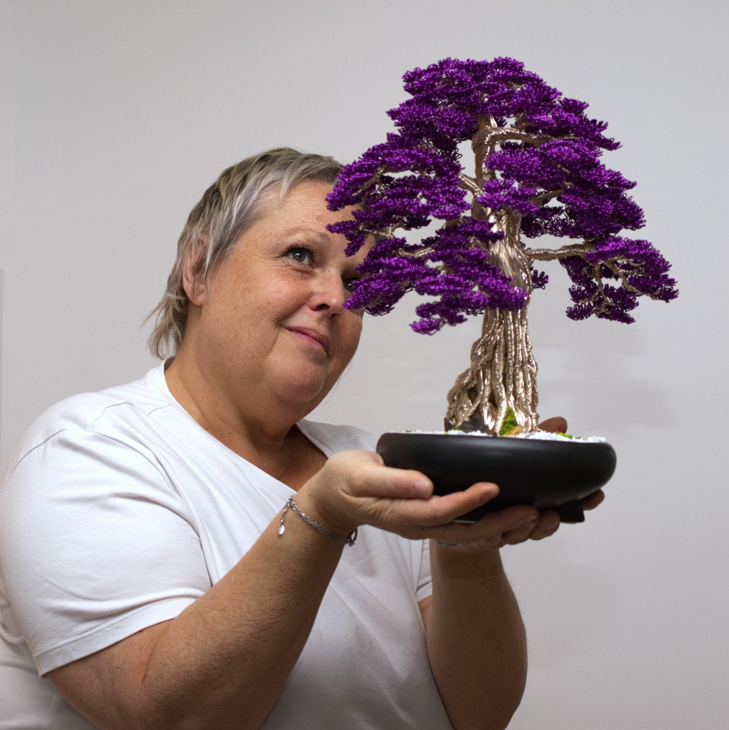 Odile Soyard, créatrice de La Canopée d'Argent, présentant un bonsaï en fil d'aluminium au feuillage violet